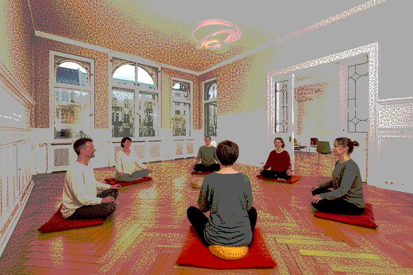 mehrere Personen sitzen im Rahmen einer Entspannungstherapie zusammen