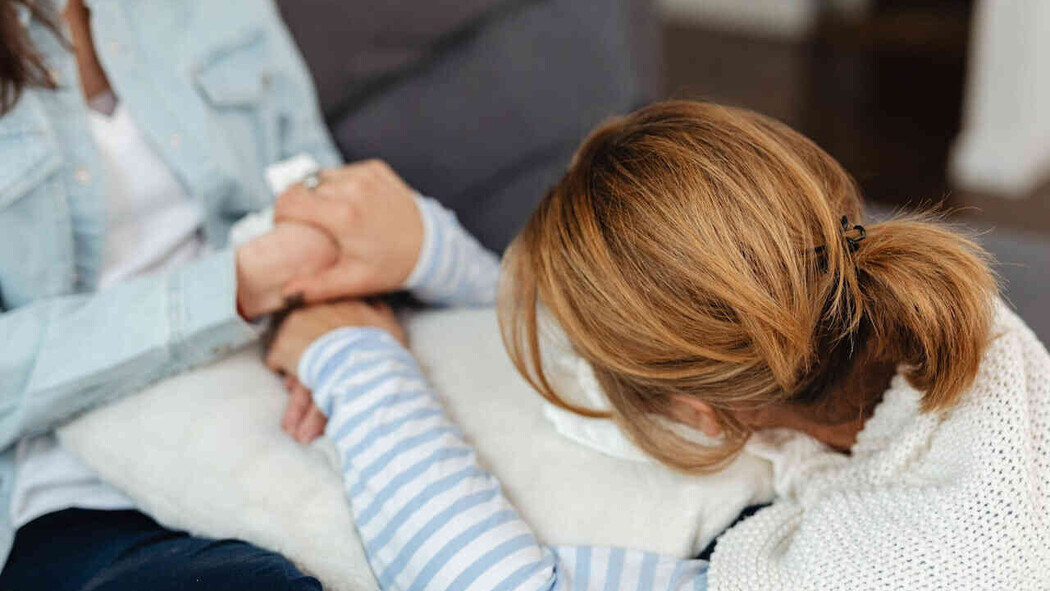 Frau h&auml;lt sich an den H&auml;nden einer anderen Frau fest