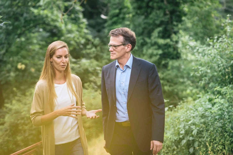 Ein mann und eine frau spazieren drau&szlig;en in der natur und unterhalten sich